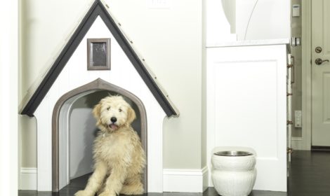 A cute little dog cottage complete with white shiplap siding and cedar shake roof. It was designed to fit in a cubby located just outside the customers laundry room.